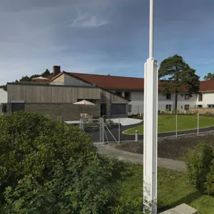 En inngjerdet hage med et hus i bakgrunnen