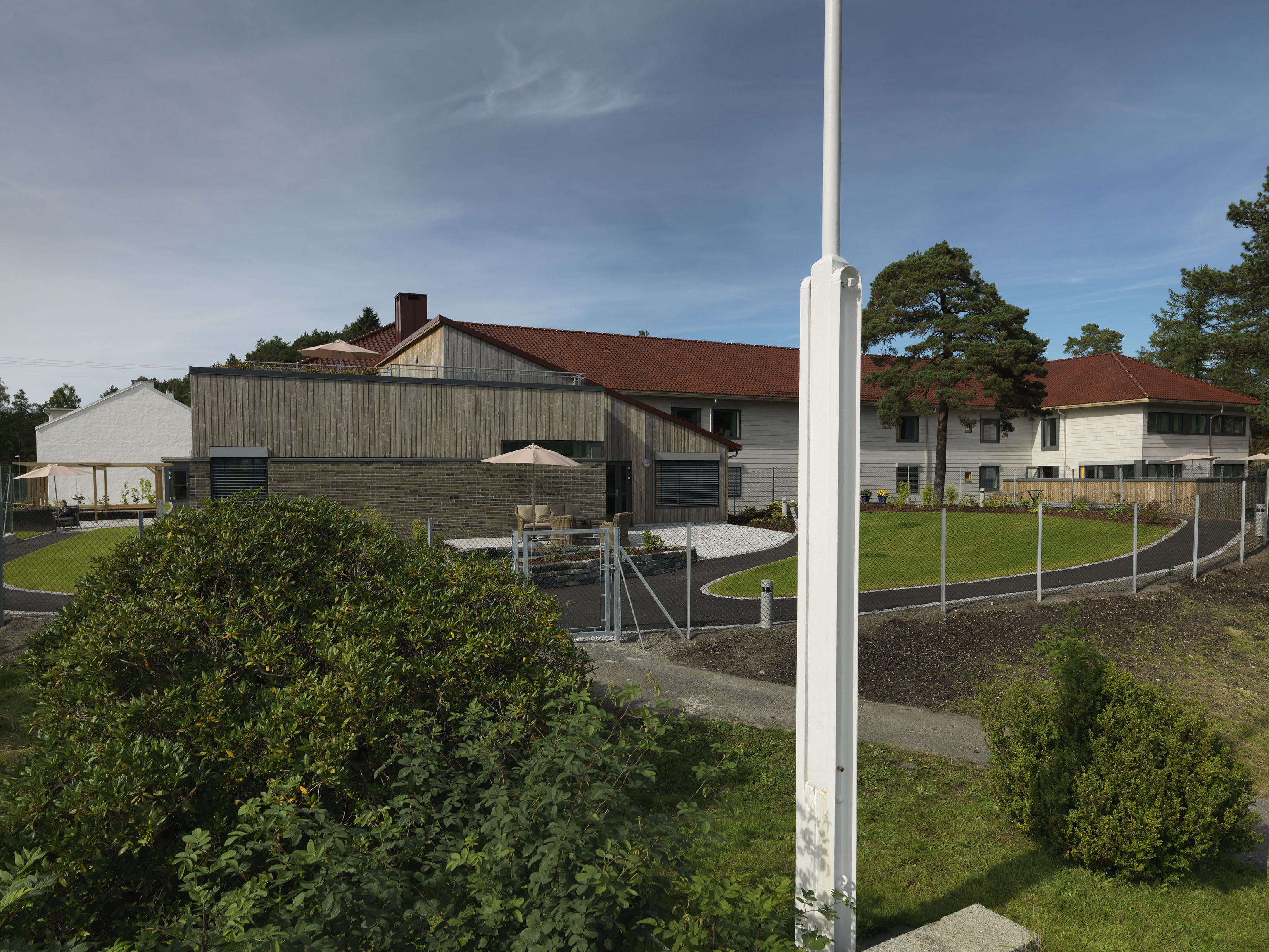 En inngjerdet hage med et hus i bakgrunnen