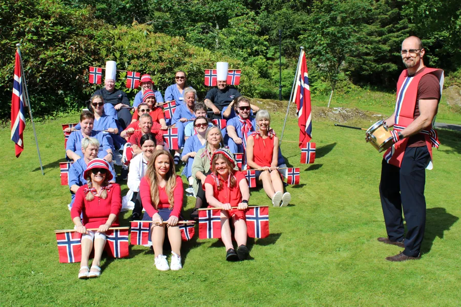 En gruppe mennesker poserer for et bilde med flagg