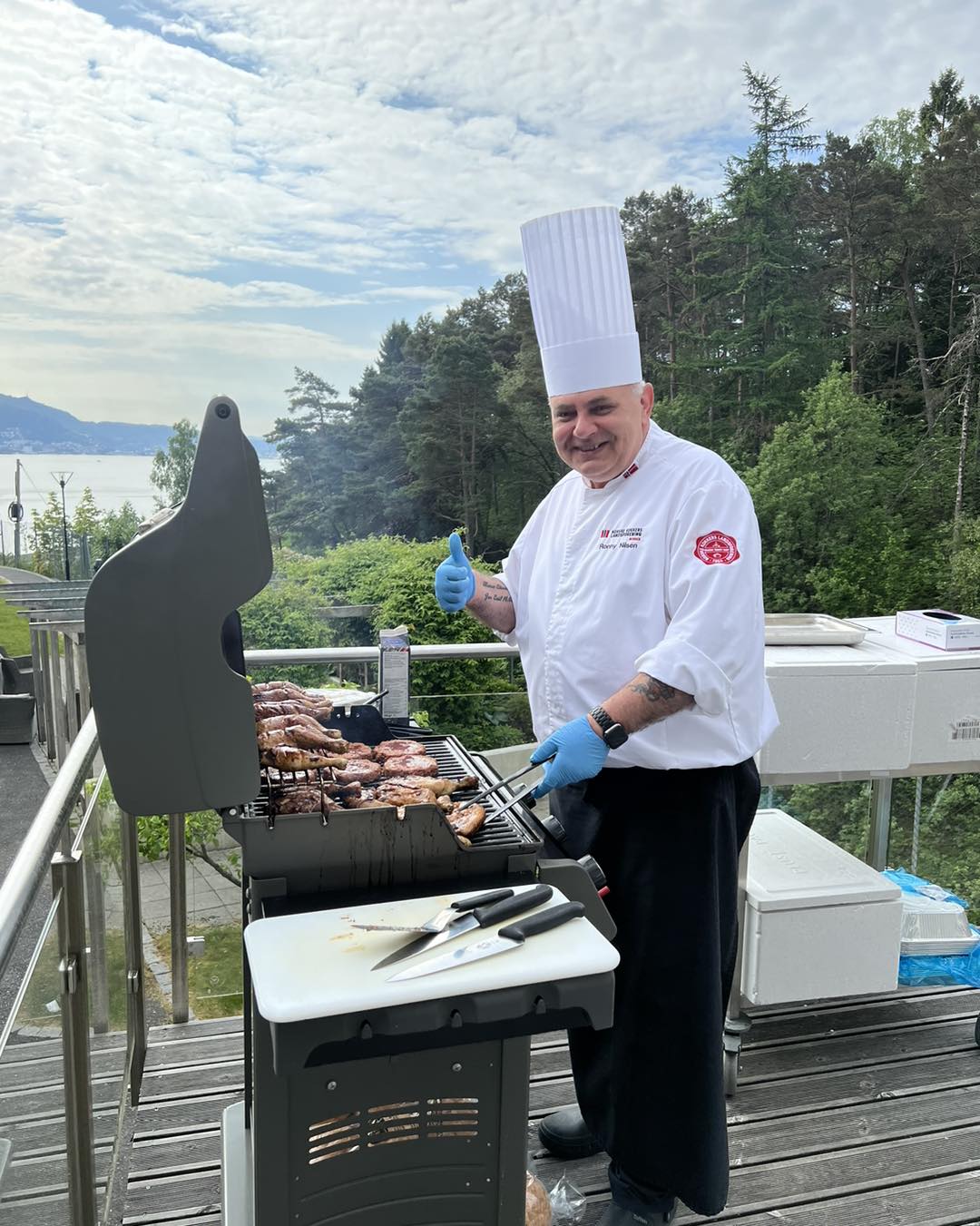 En mann som griller kjøtt på en terrasse