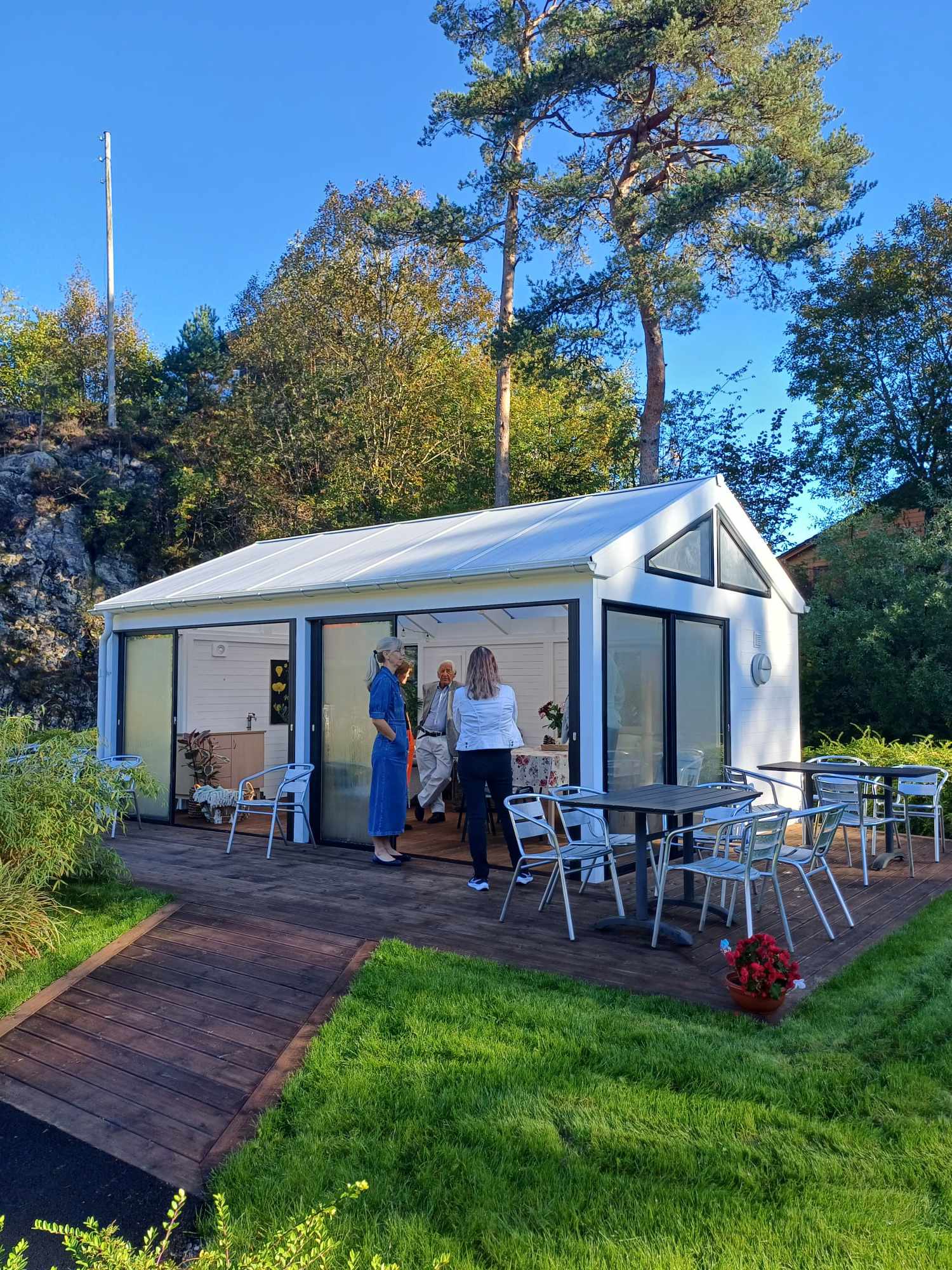 Et par kvinner som står foran den nye utestuen i hagen