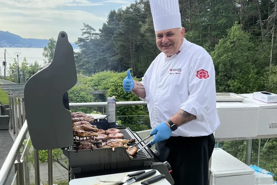 En mann som griller fisk på et dekk